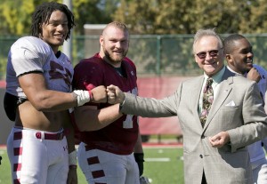 Sharif Finch, left, a junior at the Fox School of Business, bumps fists with Dr. M. Moshe Porat when the Fox School’s Dean visited one of the Temple football team’s October practices. Finch, a defensive lineman, is joined by senior Kyle Friend, the team’s starting center and a fellow Fox student. (Ryan S. Brandenberg)