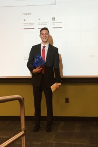 Fox School of Business student Robert Moses poses with the first-place trophy after he and his team won the Penn State Abington Business Challenge.