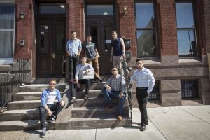 Known to discuss their businesses and friendships in impromptu locales, the entrepreneurs gather on the front steps of their Diamond Street apartment. Seated with the laptop is Clint Rosario, Beau’s brother and fellow entrepreneur. (Joseph V. Labolito/Temple University Photography)