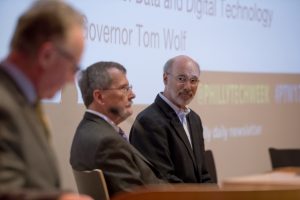 Pennsylvania Governor Tom Wolf, far right, sits with Temple University President Richard Englert, center, as Fox School of Business Dean M. Moshe Porat delivers opening remarks.