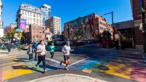 Ian and a tour group pass a mural in philly