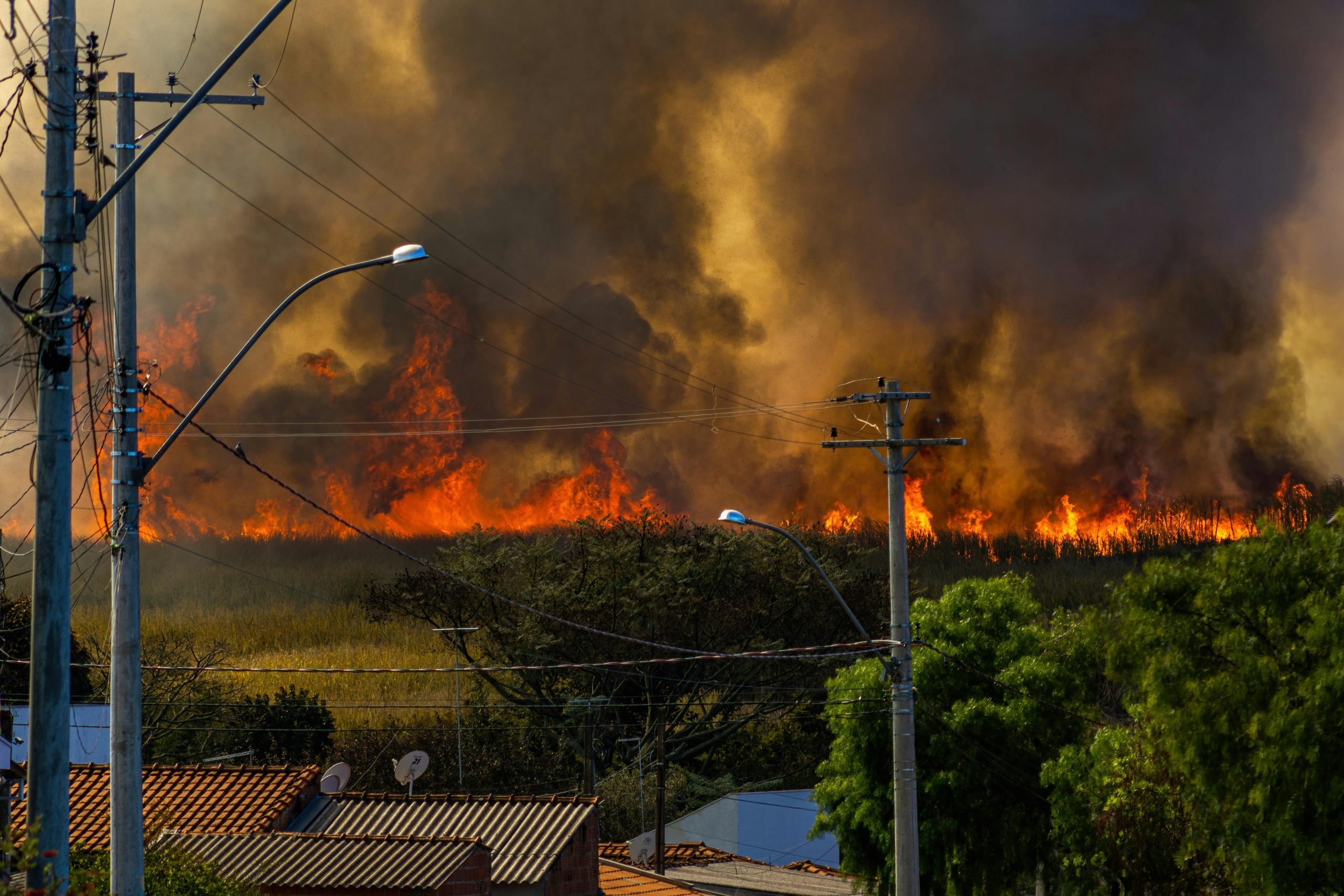 A distant wildfire seen through powerlines.
