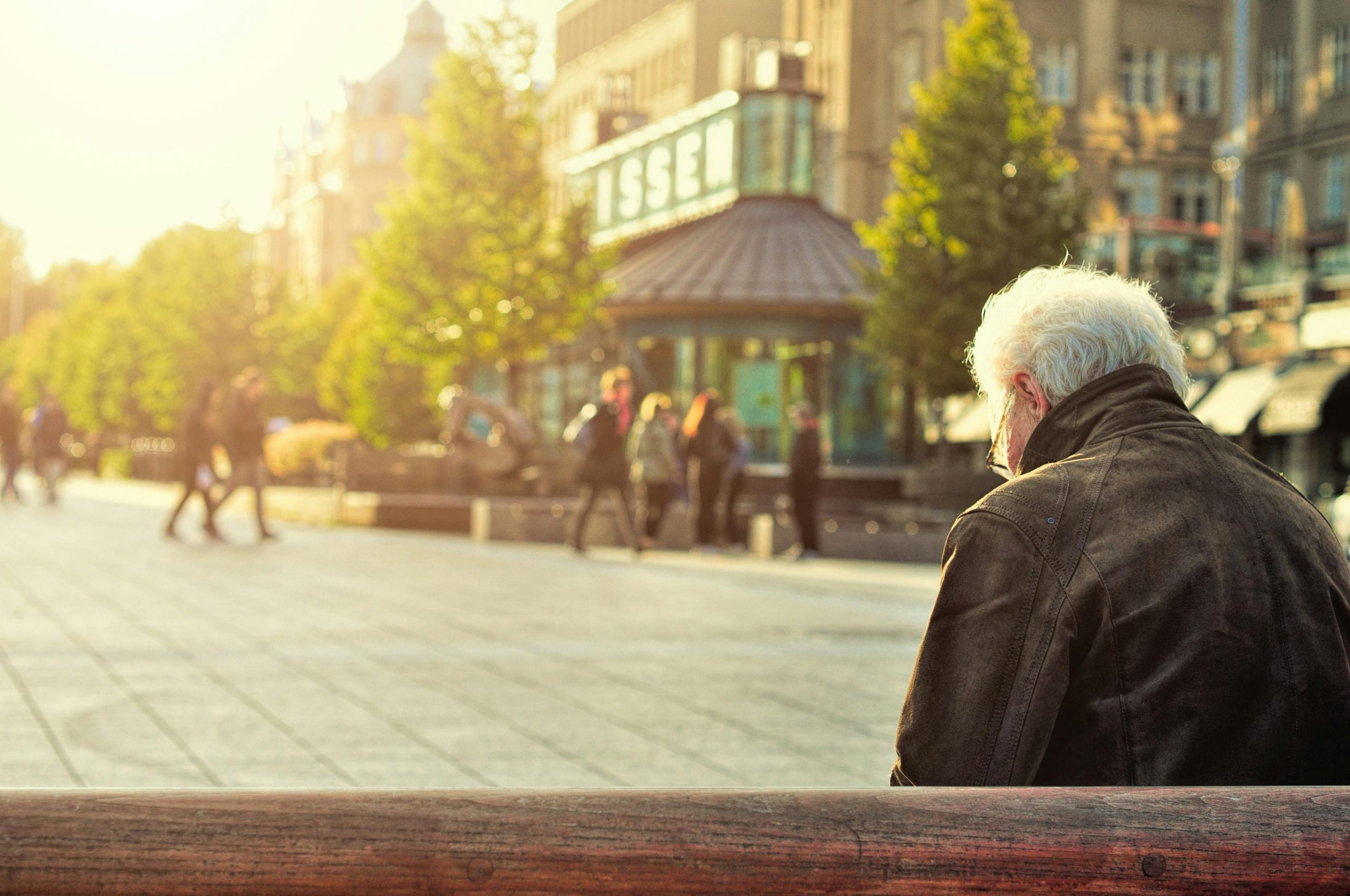 An older gentleman sits on a bench.