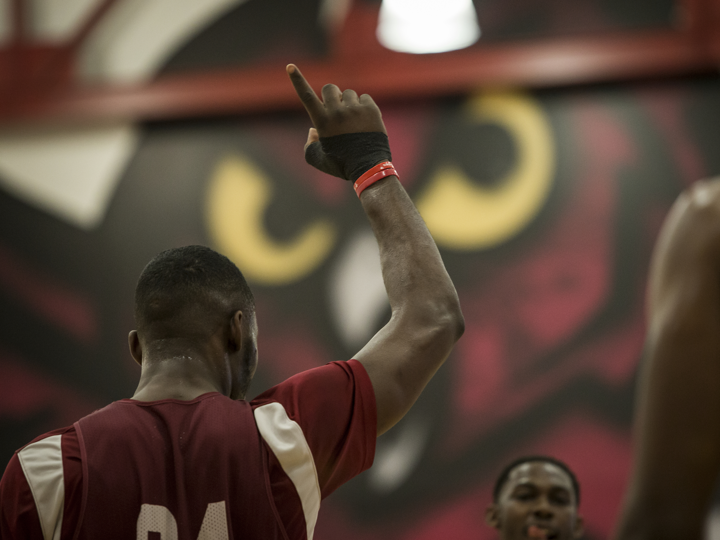 An athlete facing away from the camera, pointing upwards