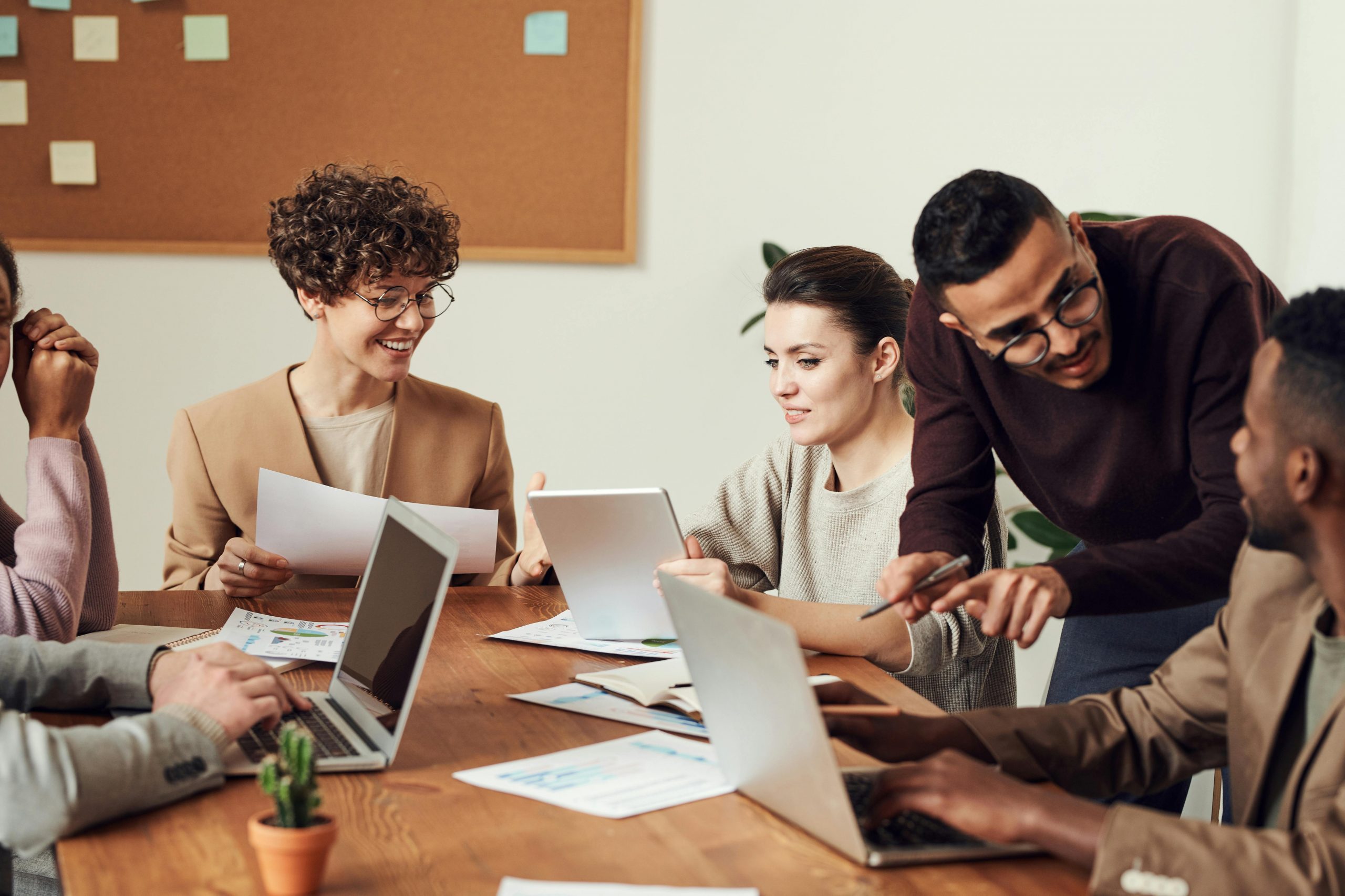 A group of coworkers gathers around a table to discuss work.