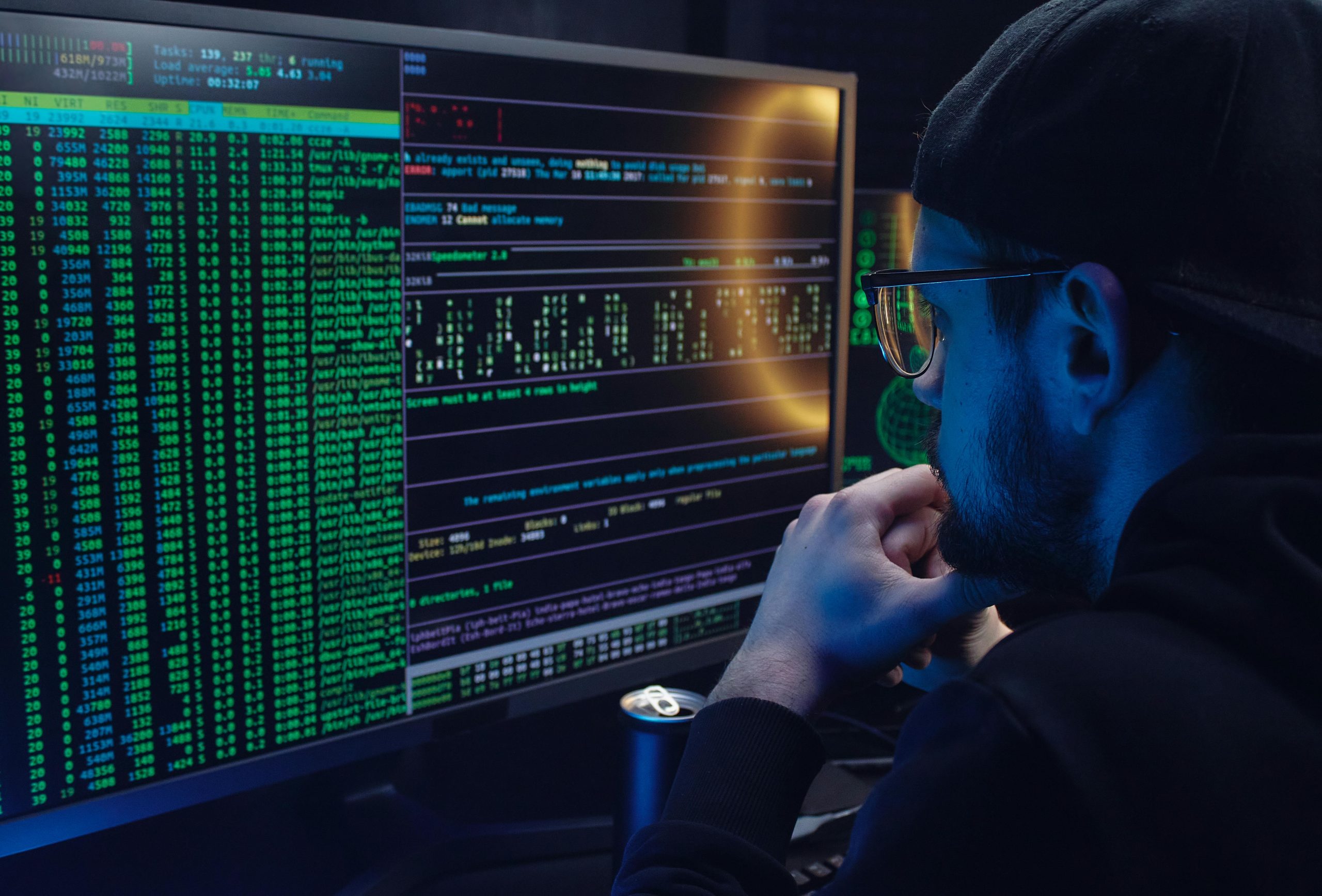 A person looks at a screen of code in the dark.