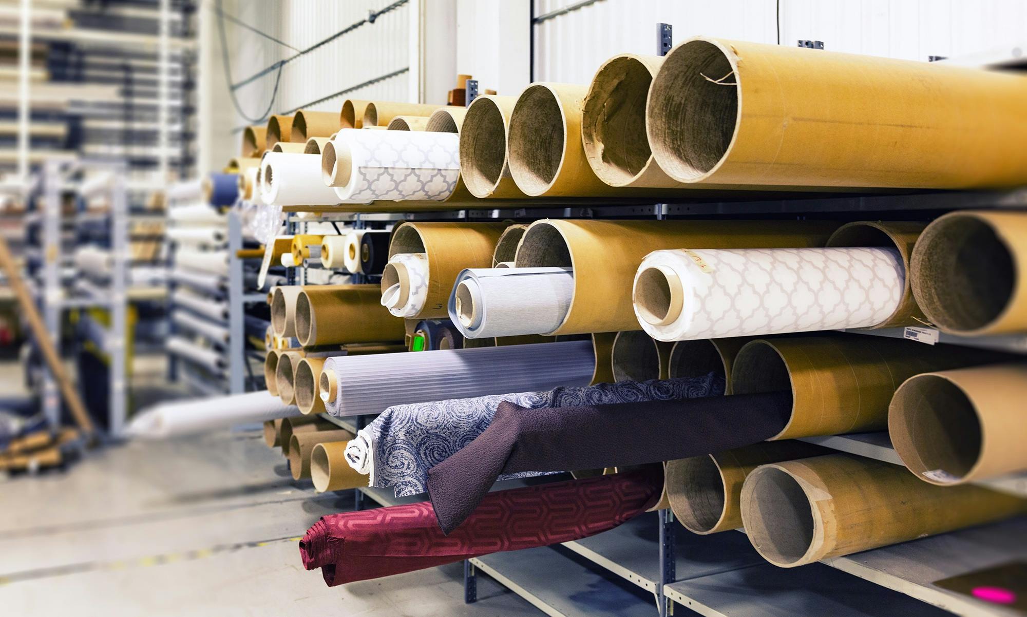 Bolts of fabric stored in a warehouse.