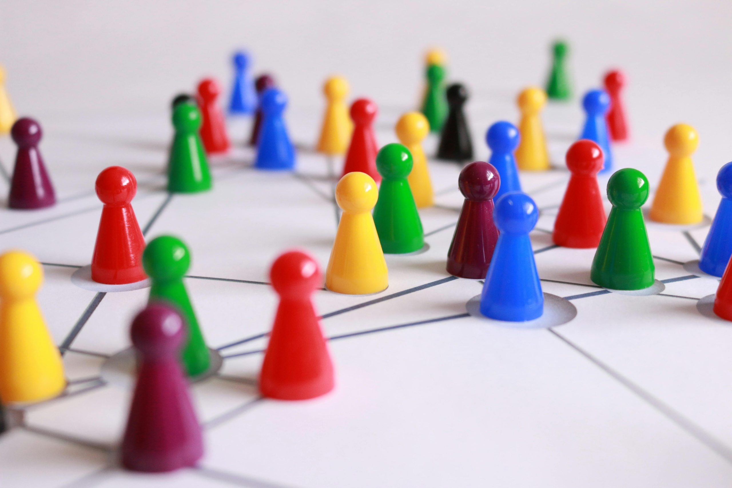 Smal abstract human figurines sit on a diagram of interconnected lines.
