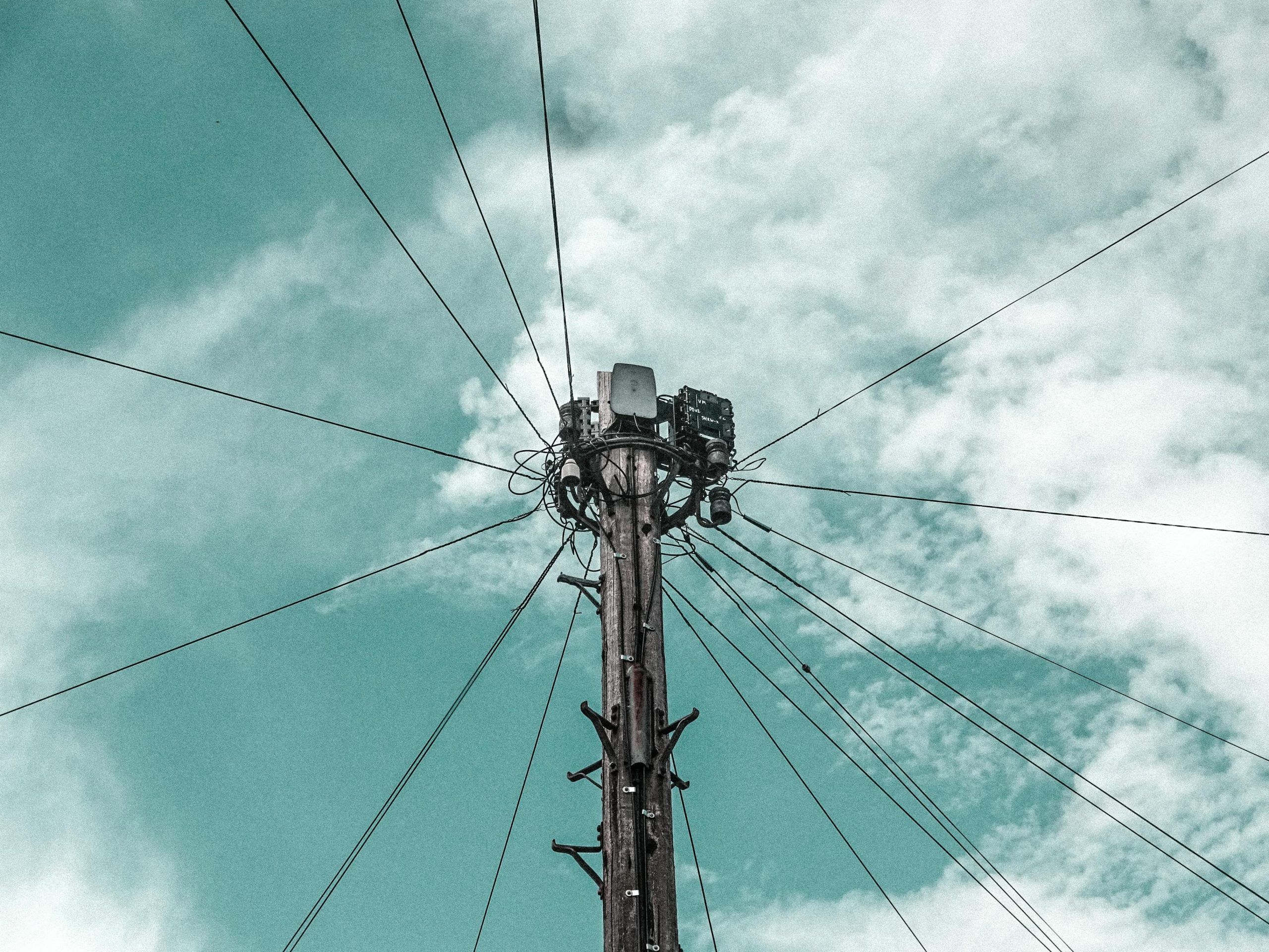 The top of a wire pole with the sky behind it.