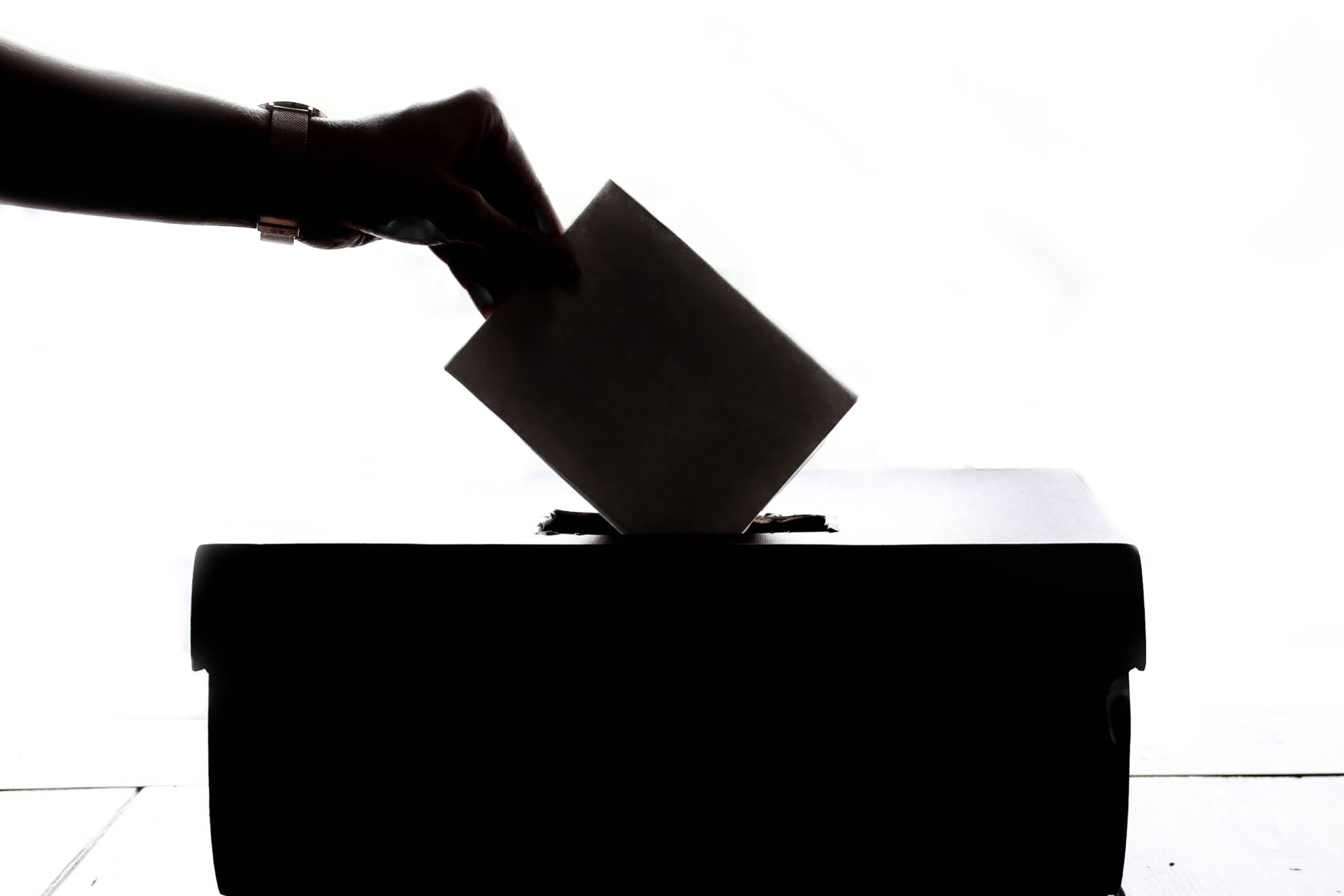 A hand dropping a letter into a box