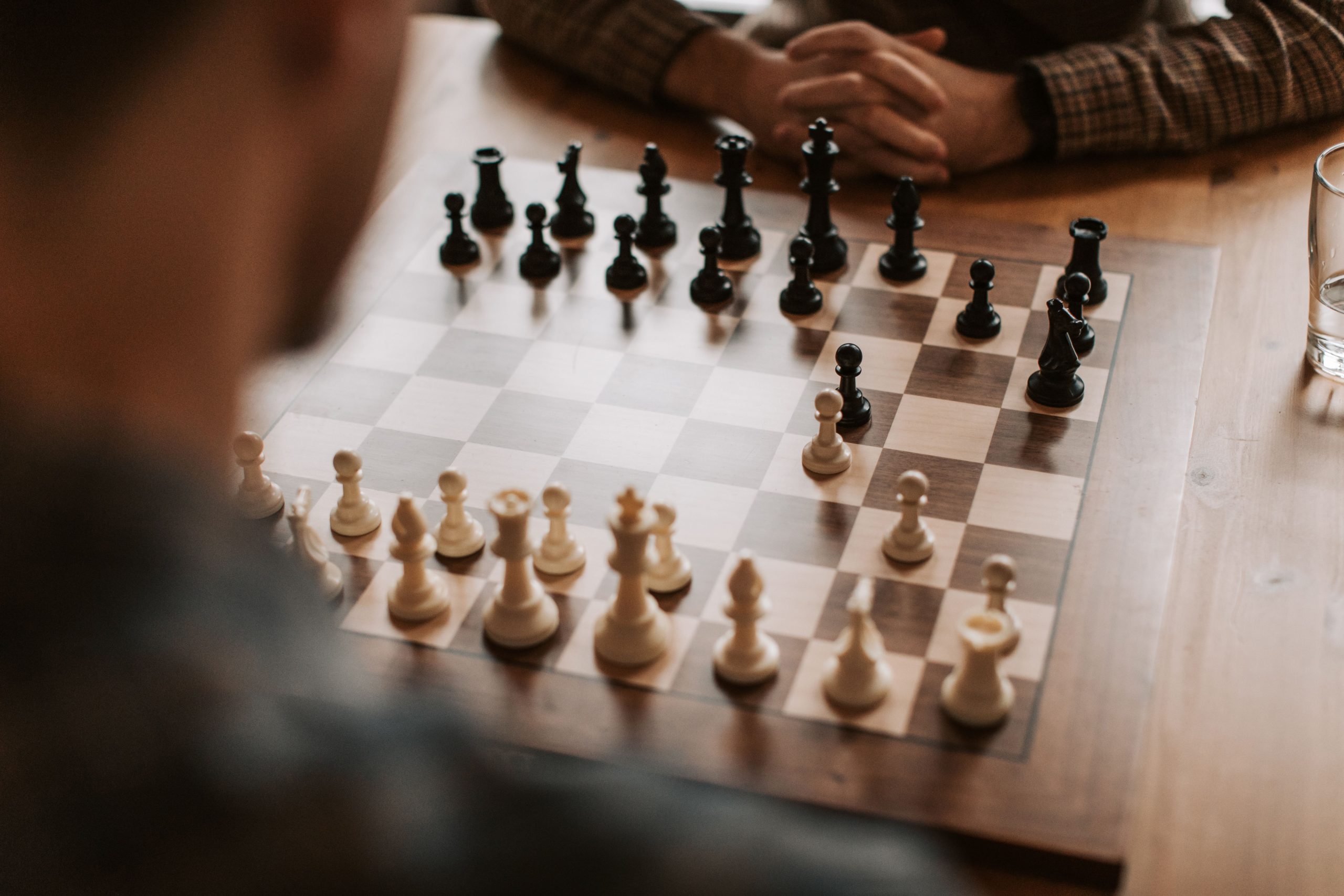 Two people sitting and playing chess.